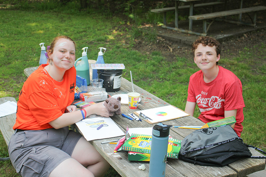 Scout and staff coloring at picnic table at custaloga town scout reservation