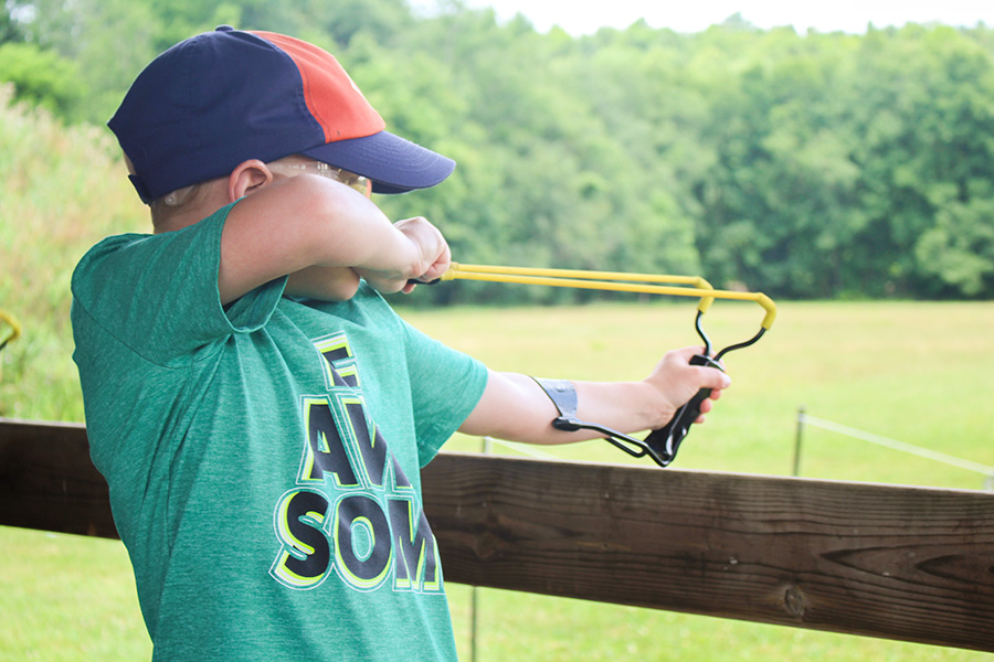 Slingshot Cub Scout pulling back a slingshot
